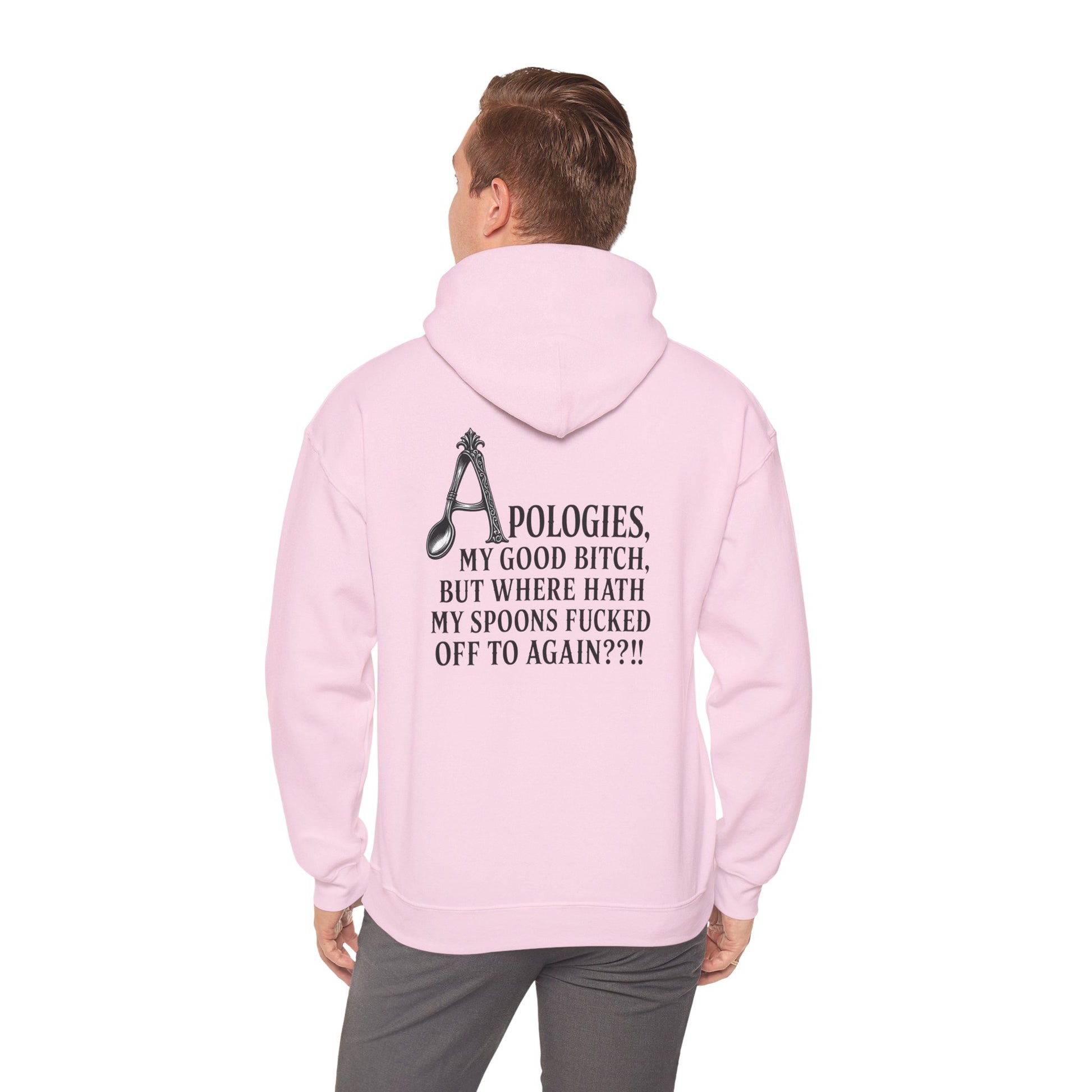A man viewed from behind wearing a light pink hoodie with a black graphic and text on the back, paired with gray pants, against a plain white background.
