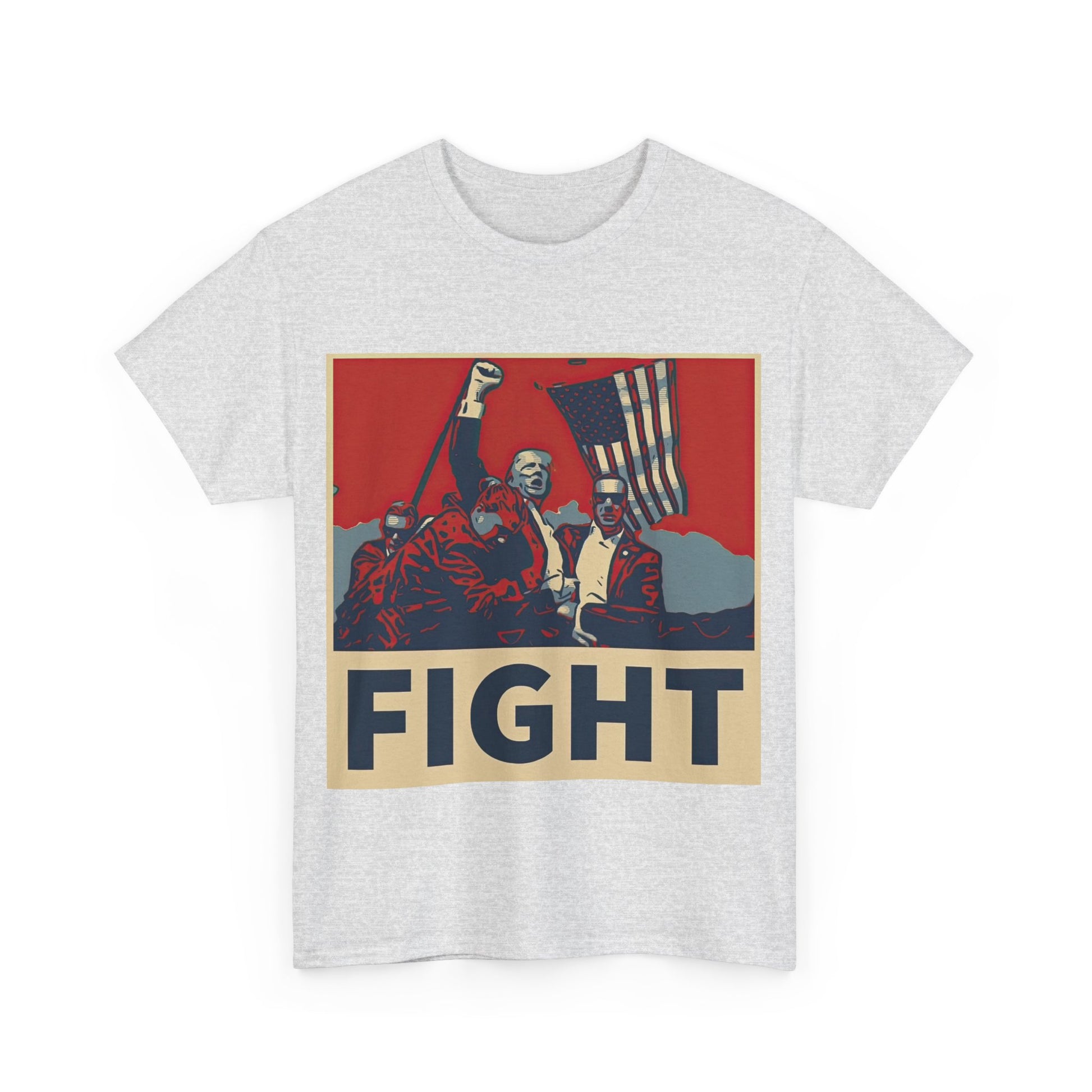 This image shows an ash-colored, unisex, heavy cotton t-shirt with a graphic design on the front. The design features a stylized, poster-like illustration of former President Donald Trump raising his fist and standing in front of an American flag. The word “FIGHT” is prominently displayed at the bottom of the illustration in bold capital letters. The graphic uses a color palette reminiscent of red, white, and blue, contributing to a patriotic theme. The t-shirt is displayed on a plain white background.