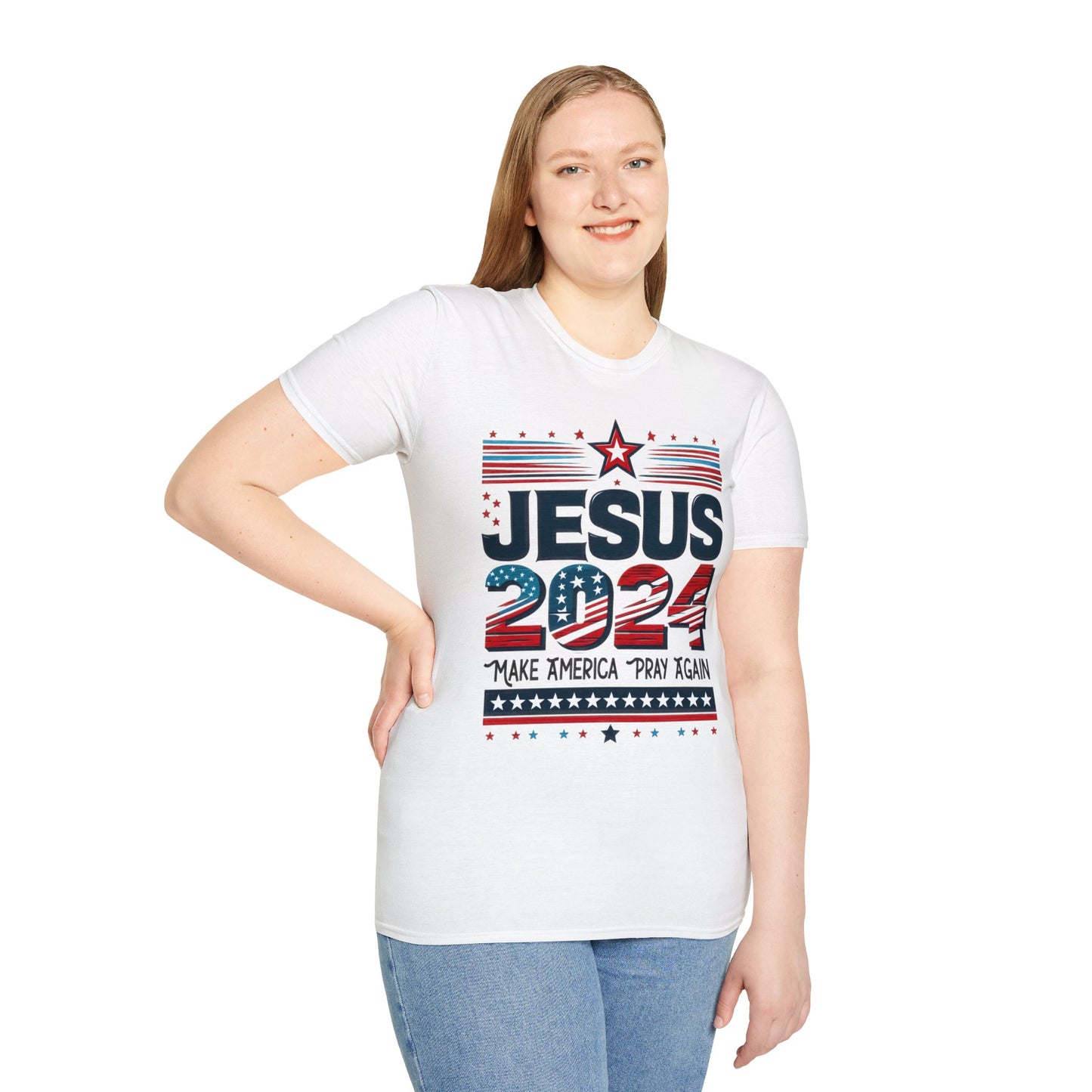 Woman wearing a white t-shirt with the design ‘JESUS 2024’ in bold letters, featuring stars and stripes. The text ‘Make America Pray Again’ is displayed below, surrounded by star accents. The woman has blonde hair, is smiling, and is standing with one hand on her hip.