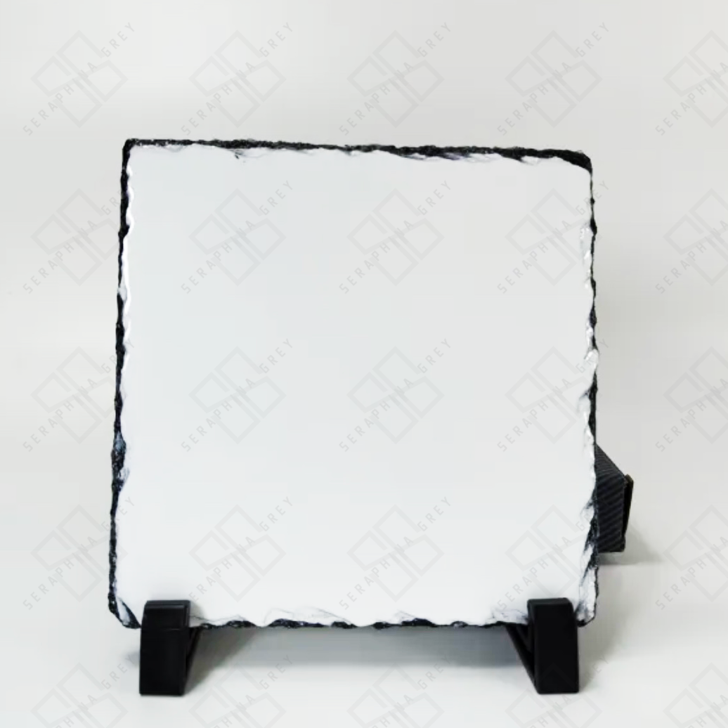 This image features a custom photo slate with a blank white surface, ready for personalization. The slate has a natural, uneven edge that gives it a rustic and unique look. It is displayed on a black stand against a white background. The watermark with “Seraphina Grey” is visible on the slate, indicating the brand.