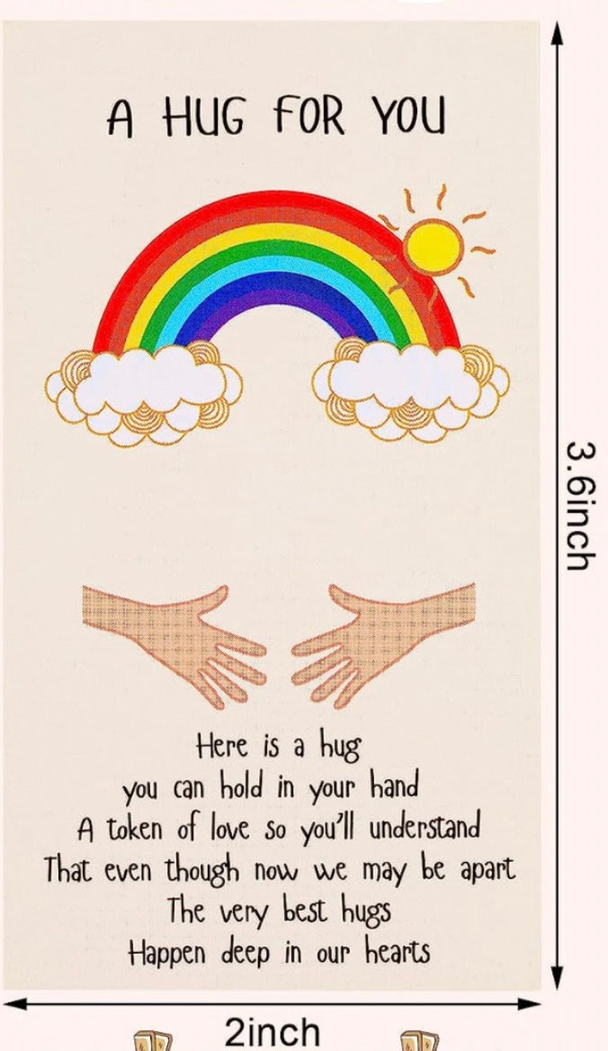 An illustration featuring the text ‘A Hug For You’ at the top, with a colorful rainbow, clouds, and sun above two outstretched hands. Below the hands, a heartfelt message reads: ‘Here is a hug you can hold in your hand, a token of love so you’ll understand that even though now we may be apart, the very best hugs happen deep in our hearts.’ The dimensions of the card are labeled as 3.6 inches in height and 2 inches in width