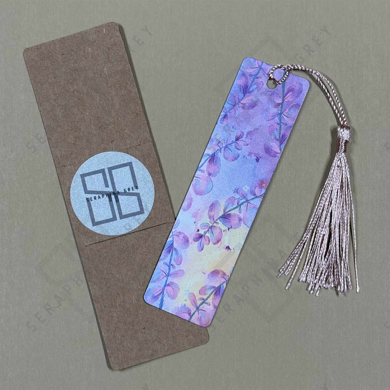 Floral bookmark with pink tassel on a gray background