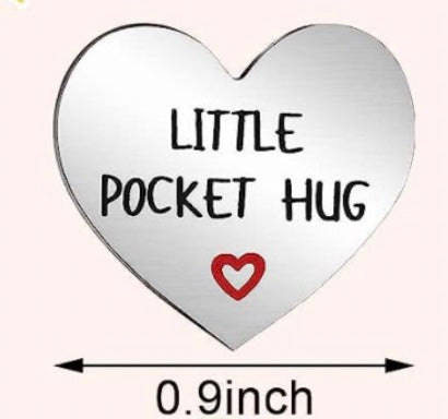 A small heart-shaped object labeled ‘Little Pocket Hug’ with a small red heart symbol below the text. The width of the object is marked as 0.9 inches. The design is simple, with a plain background.