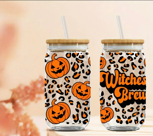 ith orange jack-o’-lanterns, leopard print patterns, and the words “Witches Brew” in bold, spooky font. The tumbler has a bamboo lid and a clear reusable straw, blending festive and eco-friendly elements. Perfect for sipping beverages during the spooky season