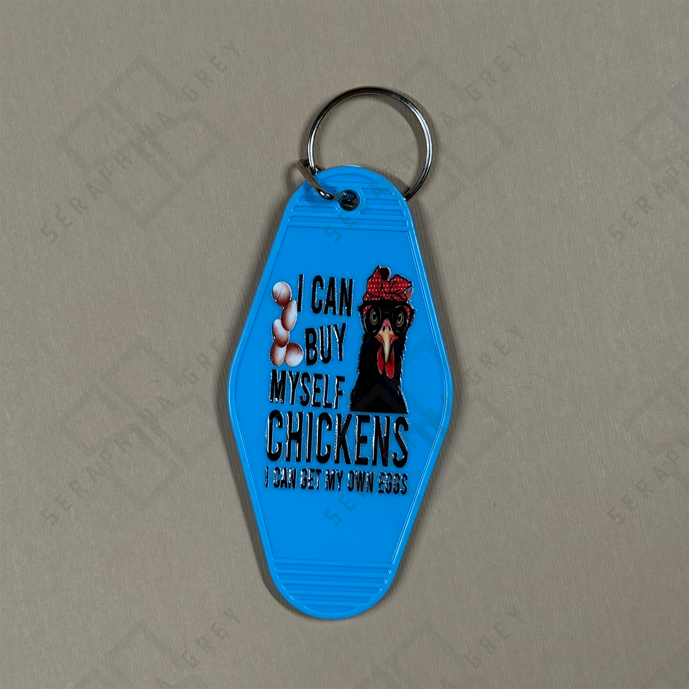 Blue keychain with a chicken graphic and the text I can buy myself chickens 