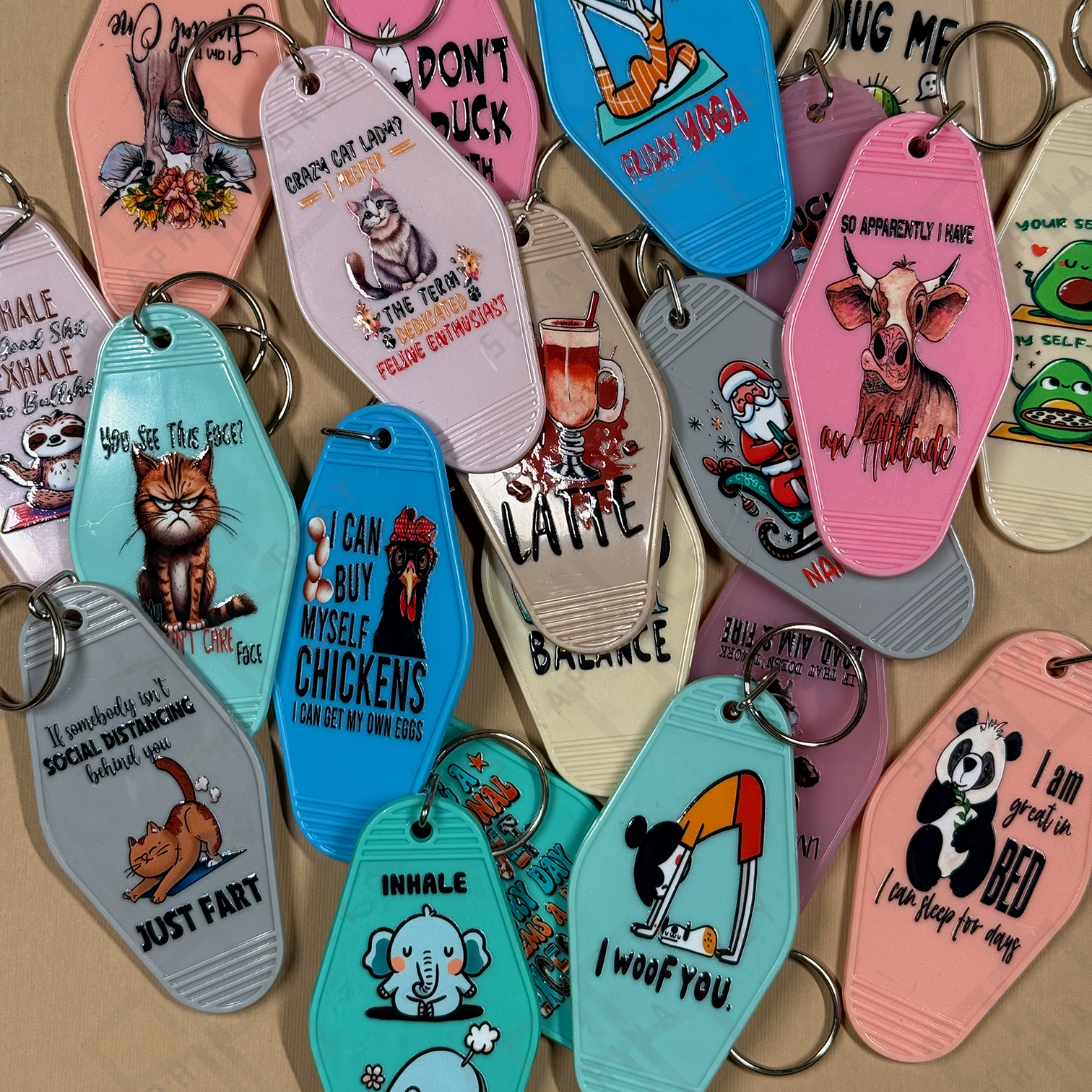 Collection of colorful keychains with various designs on a beige background