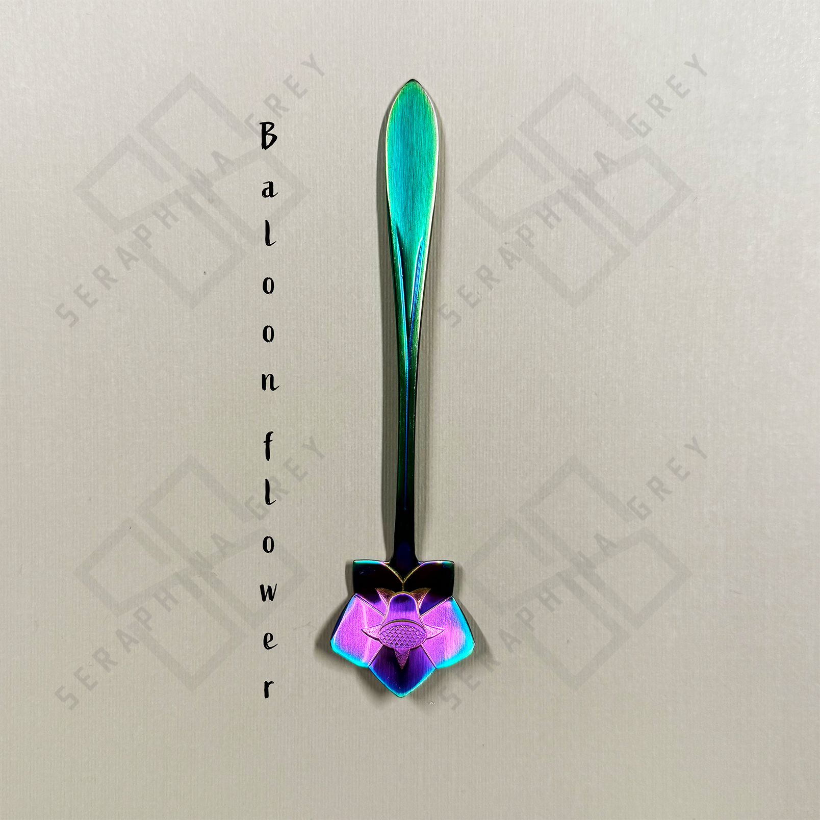 Rainbow Spoon with a balloon floral design on a branded background