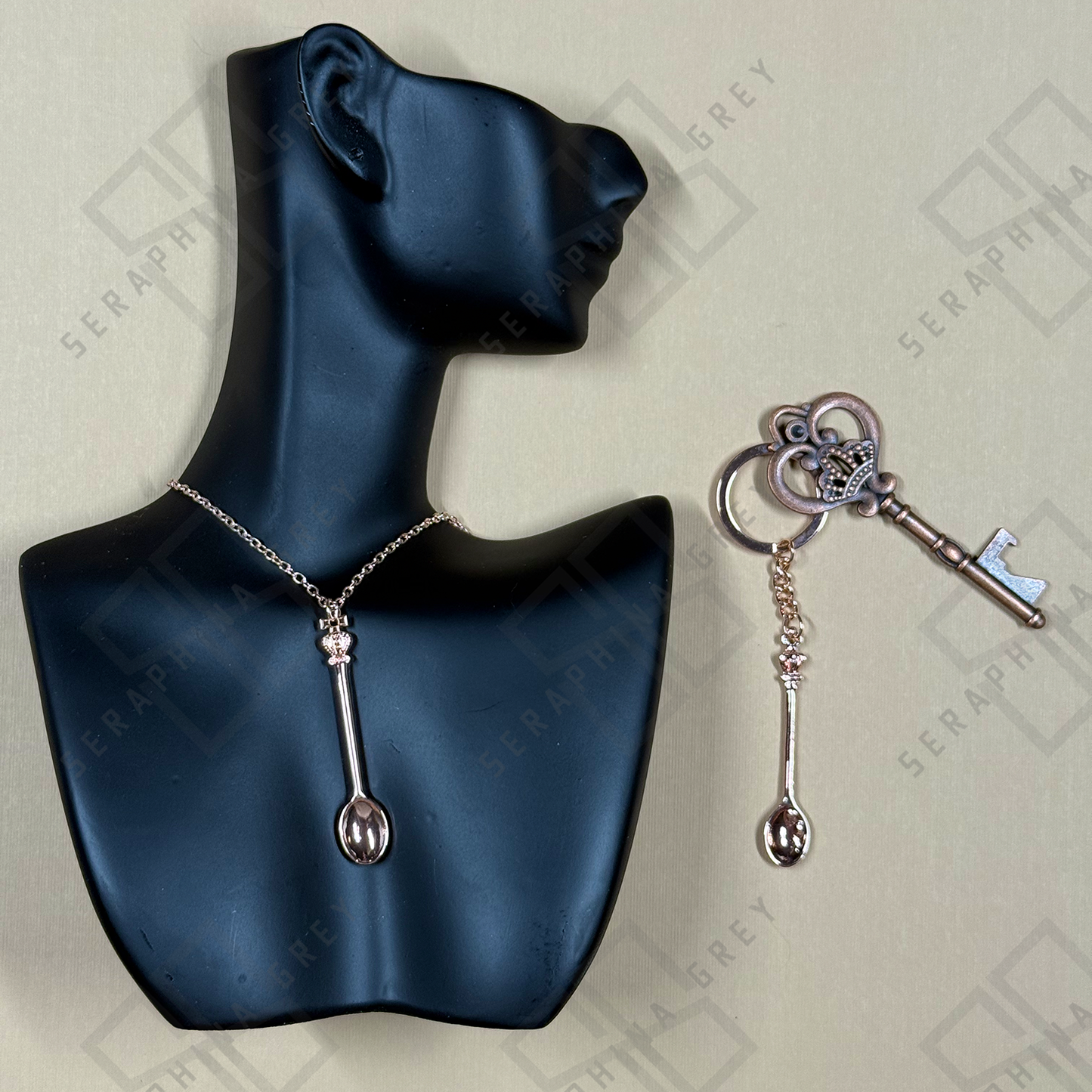 Black mannequin bust with silver necklace and keychain on a light gray background