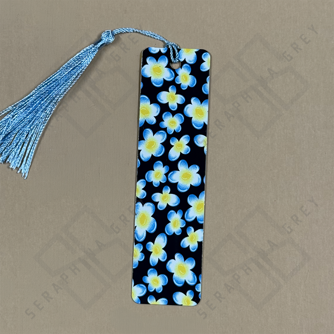 Floral bookmark with blue tassel on a beige background