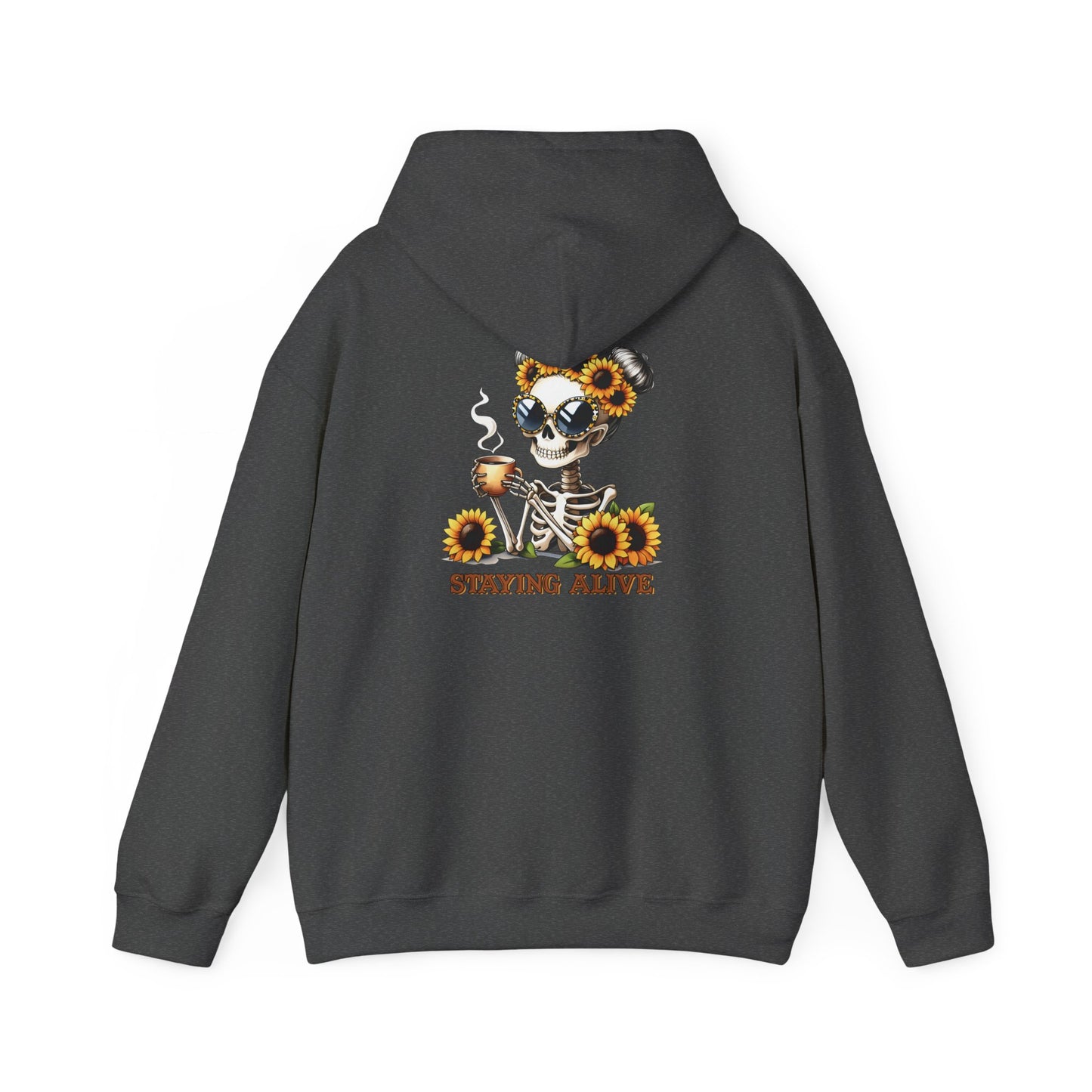 A dark heather-colored pullover hoodie shown from the back, featuring a skeleton wearing oversized sunglasses and sunflower space buns, holding a steaming mug, with “STAYING ALIVE” printed below.
