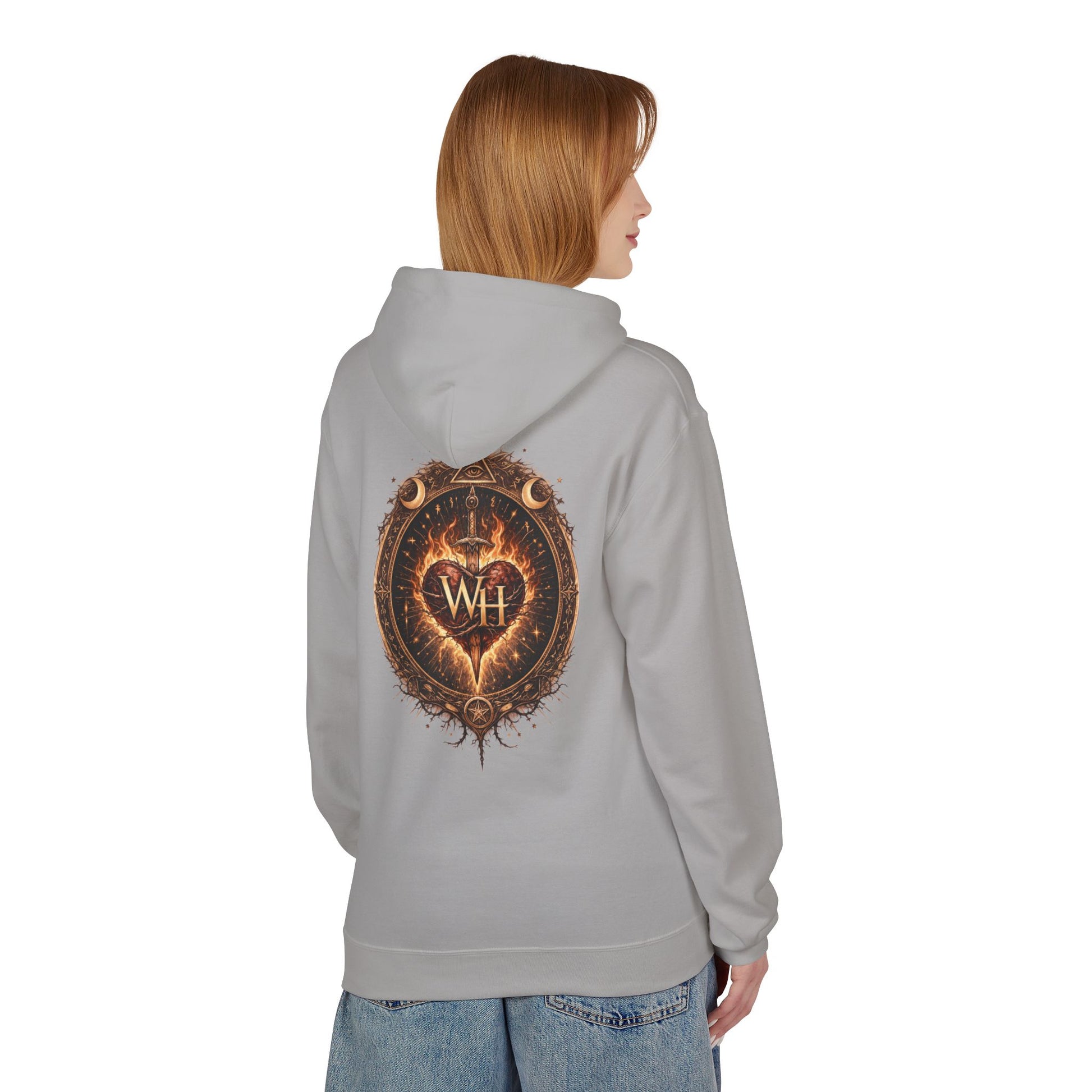 Model wearing a cement-colored pullover hoodie shown from the back, featuring the large circular “Wild Heart” mystical crest with a flaming heart, sword, crescent moons, stars, and “WH” monogram in warm brown and orange tones.