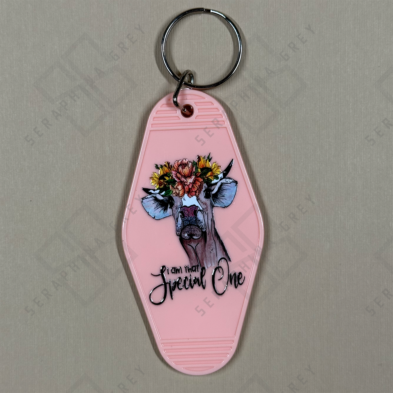 Pink Keychain with cow design and floral headband that says I am a special one